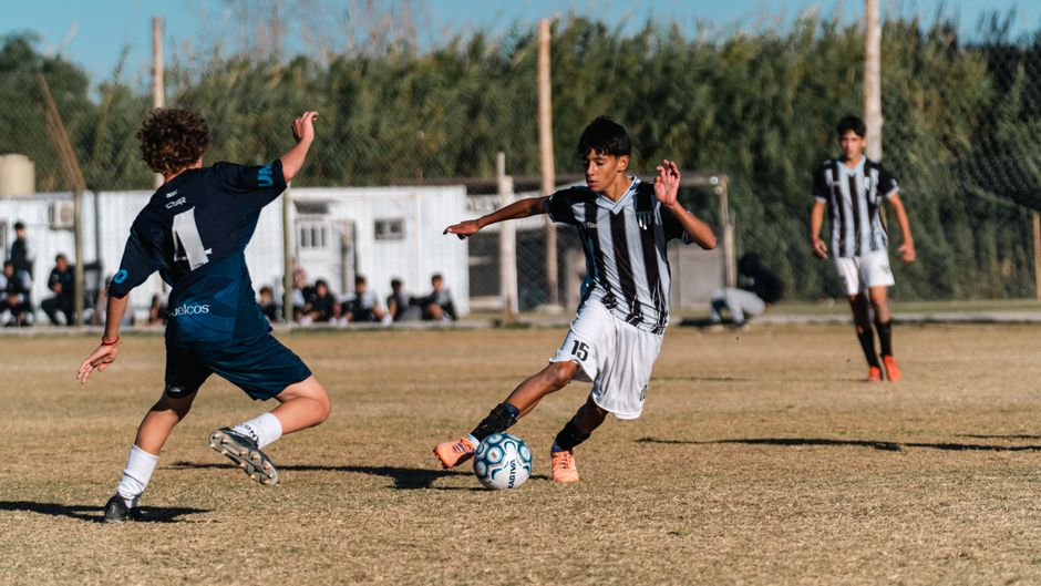 Boys playing soccer outdoors, showcasing teamwork and sportsmanship under clear skies.