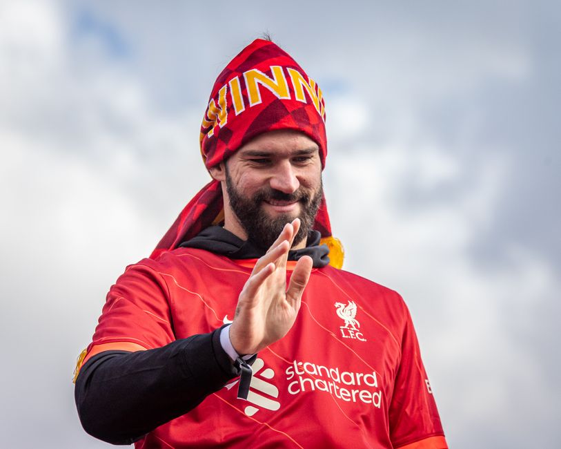 Liverpool FC player joyfully celebrates victory under the clear sky.